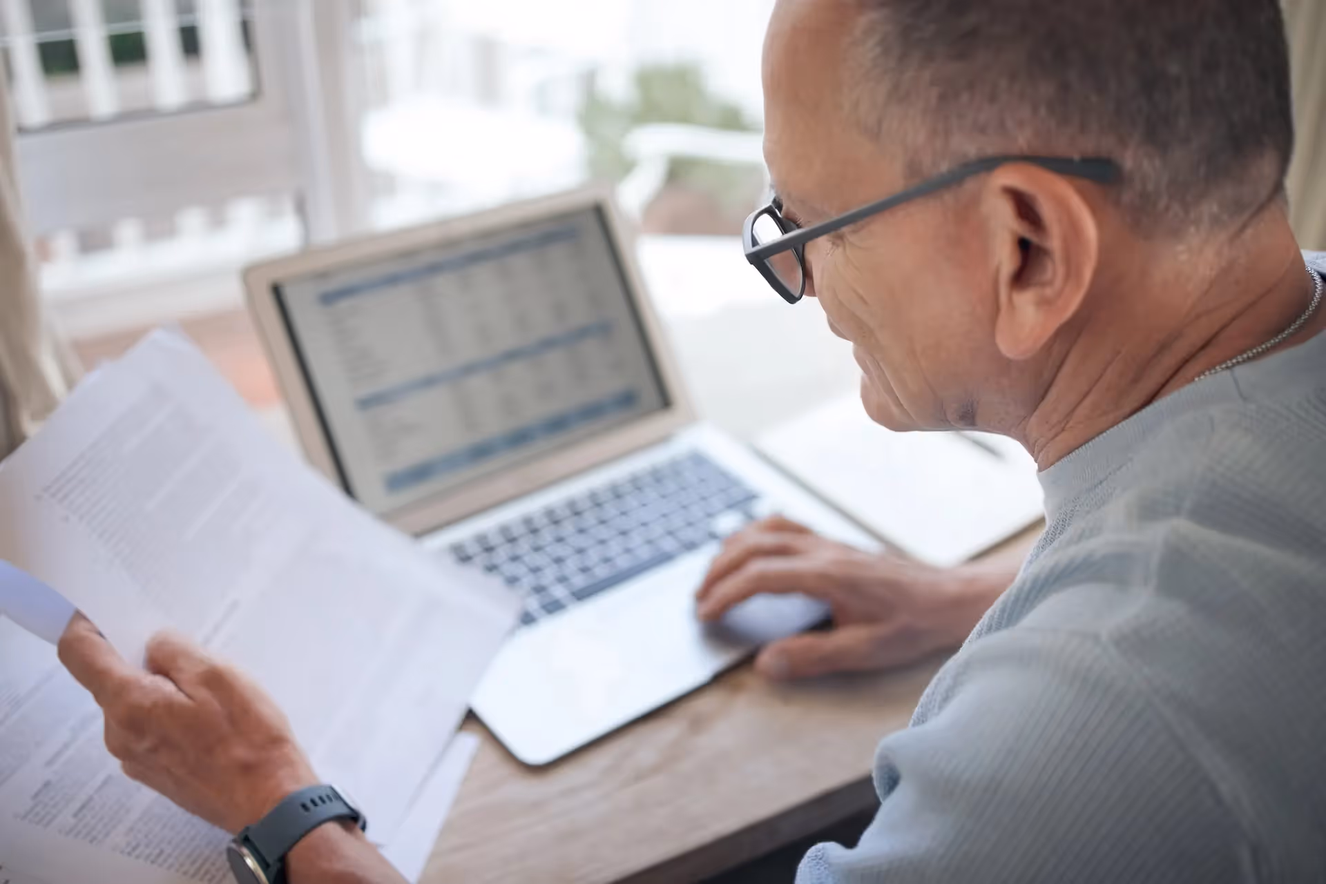 Mature professional reviewing contacts — Financing the Deal