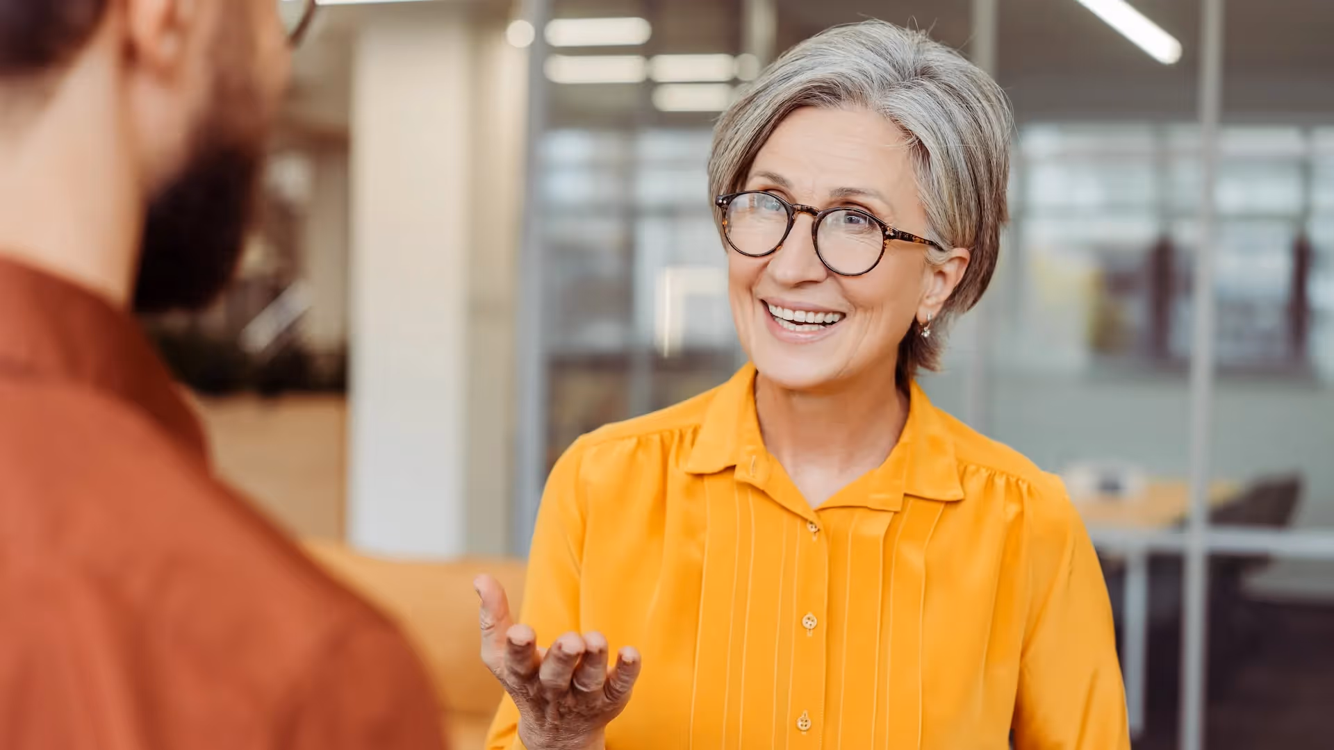 Smiling confident senior woman in conversation — Asset Sale vs Stock Sale