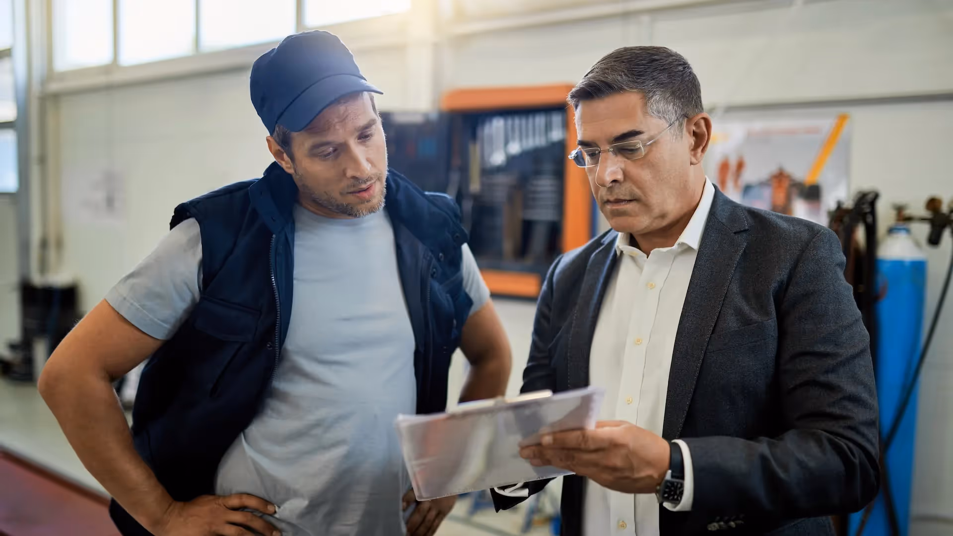 Auto repairman and manager reviewing paperwork — From Operator to Advisor