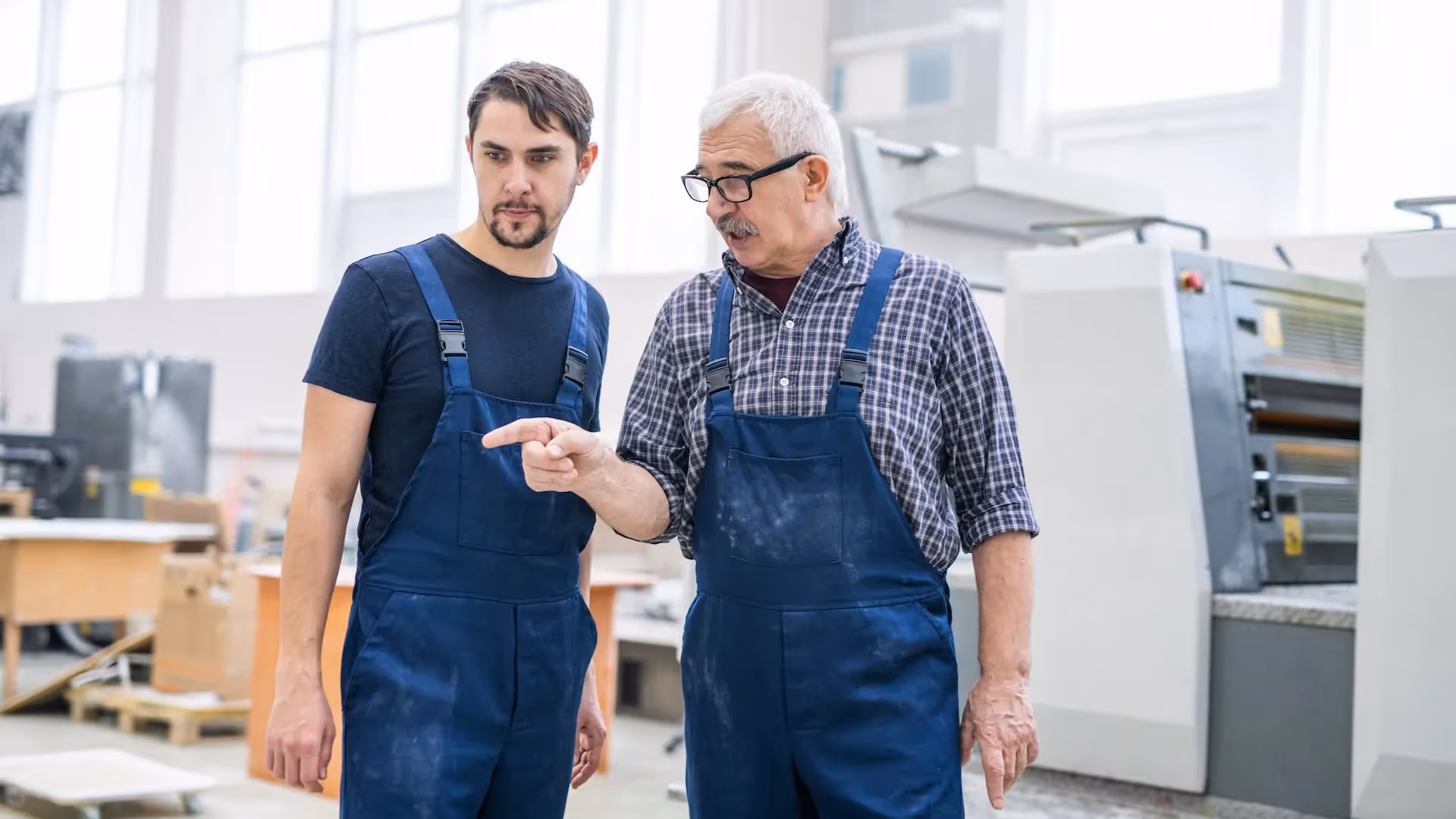 Manager giving task to young printing specialist — How to Sell Your Business