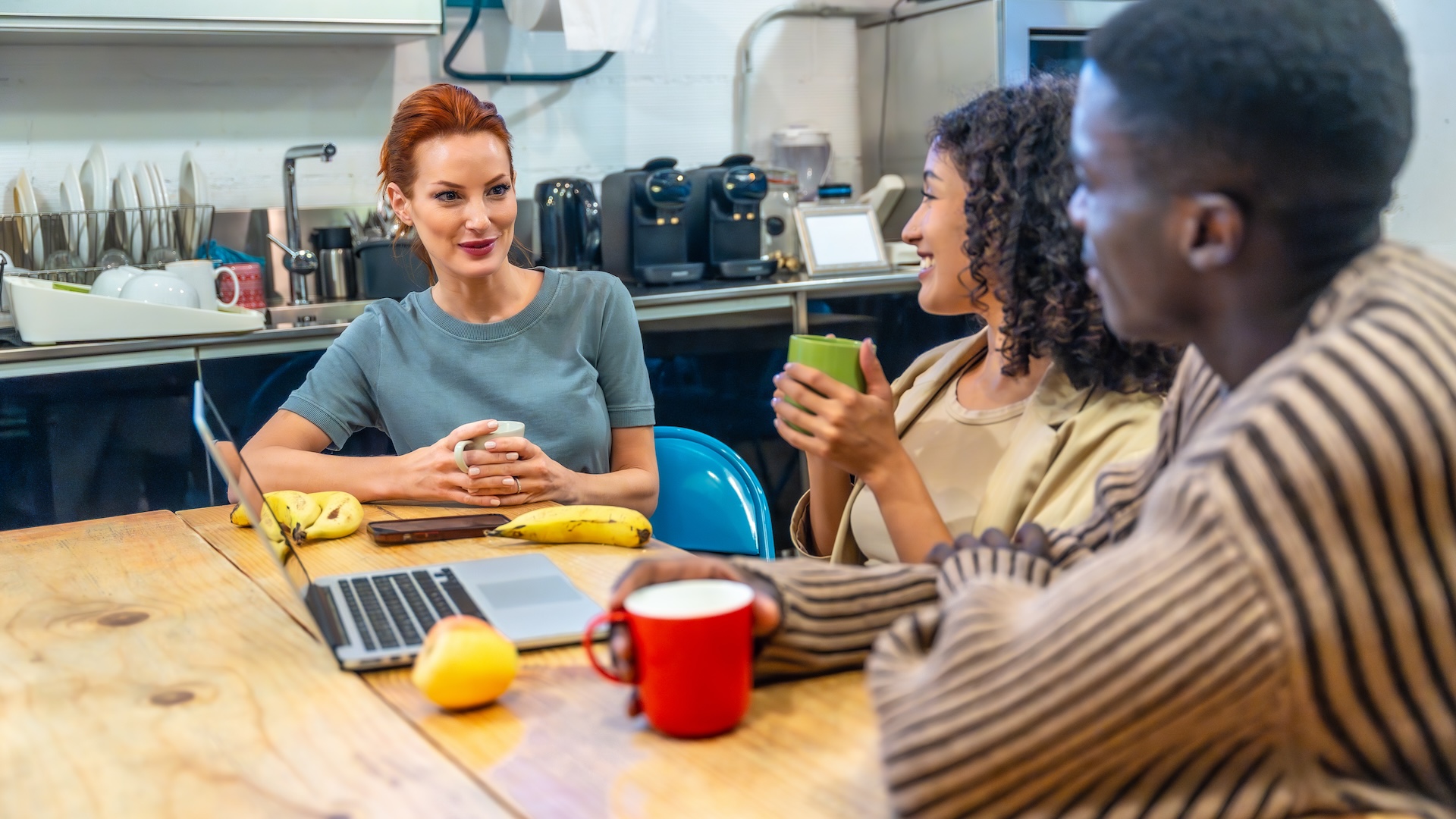 Image of coworkers eating and drinking coffee at work
